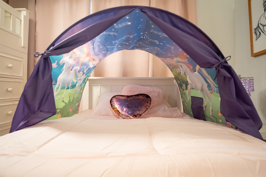 Kids bed with magical unicorn bed tent over the top.